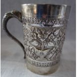 AN EMBOSSED SILVER TANKARD with elephant's head and trunk handle, 12.5cm high, approx 13.10oz