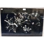 AN ORIENTAL BLACK LACQUERED PANEL inlaid with mother of pearl bamboo branches, foliage and birds,