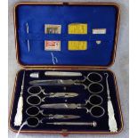 A VICTORIAN MANICURE SET, in a fitted red leather case, with polished steel scissors