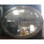 AN ARTS AND CRAFTS STYLE OVAL COPPER FRAMED WALL MIRROR, with hammered finish and repousse