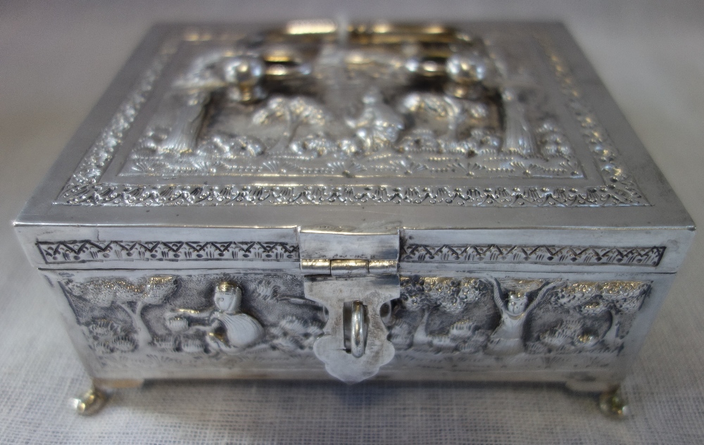 A SILVER EMBOSSED CASKET, with hinged lid and scrolled handle, 12cm wide x 10cm deep, approx 9.10oz