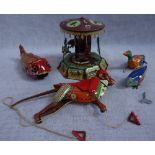 A VINTAGE TINPLATE CLIMBING MONKEY, 22cm high, a tinplate clockwork merry-go-round, a tinplate