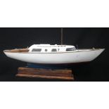 A VINTAGE POND YACHT with a blue and white fibreglass hull and wooden fittings, 86cm long