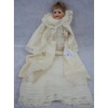 AN EDWARDIAN BISQUE HEADED DOLL with glass eyes and composite body with limbs and original clothing,