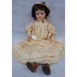 G.M. BERGMAIN; A GERMAN BISQUE HEADED DOLL, with glass eyes and jointed composite body, 61cm high (