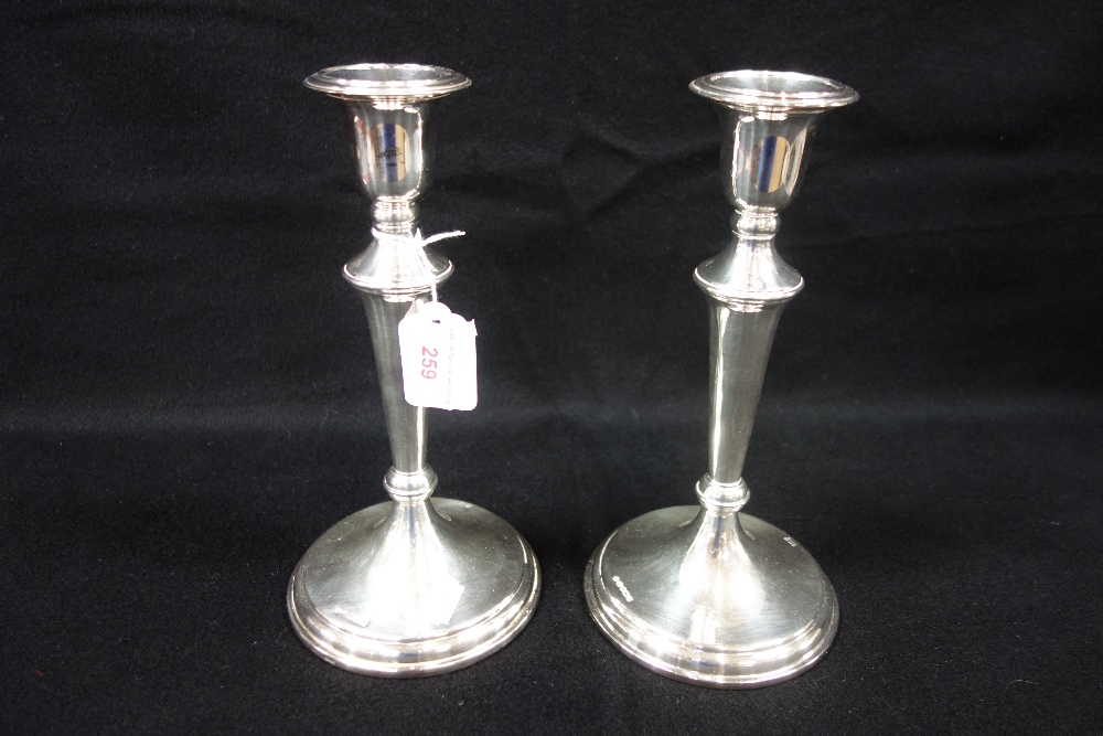 A PAIR OF SILVER CANDLESTICKS, 25cm high (filled)