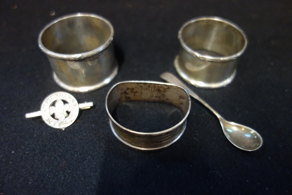 THREE SILVER NAPKIN RINGS, a mustard spoon and a brooch (5)