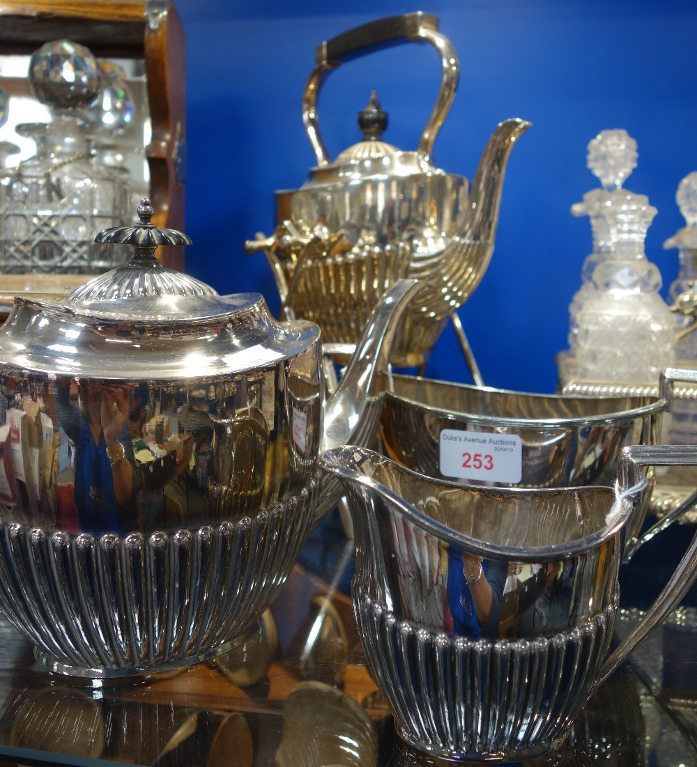 A SILVER PLATED SPIRIT KETTLE and a similar three piece teaset