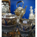 A SILVER PLATED SPIRIT KETTLE and a similar three piece teaset