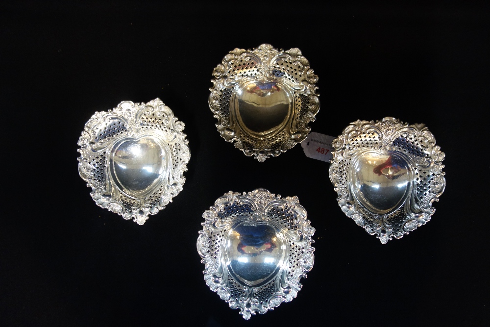 HUNT & ROSKILL LATE STORR AND MORTIMER: A collection of four silver pierced heart shaped dishes,