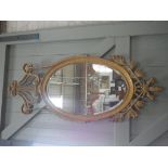 A LARGE GILT FRAMED OVAL WALL MIRROR, with swag decoration, 161cm high x 65cm wide