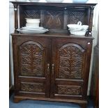 A VICTORIAN CARVED OAK CUPBOARD, with raised back and shelf, 149.5cm high x 112cm wide