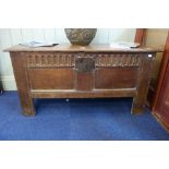 A 17TH CENTURY OAK COFFER with a panelled and carved front, 112cm wide