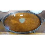 AN OVAL OAK TRAY with silver plated gallery and feet with plated central shield