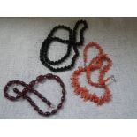 AN 'AMBER' NECKLACE, together with a 'coral' necklace and black bead necklace (3)