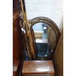 AN EDWARDIAN OVAL FRAMED WALL MIRROR, a collection of walking sticks and a Cossor Melody Maker model