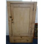 A VICTORIAN STRIPPED PINE CUPBOARD fitted a single door with drawer below, 127cm high x 76cm wide