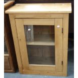 A VICTORIAN STRIPPED PINE CABINET, fitted a single glazed door, 76cm high x 62cm wide