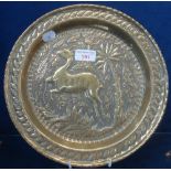 A REPOUSSE BRASS DISH decorated with a frolicking deer, in the manner of John Pearson