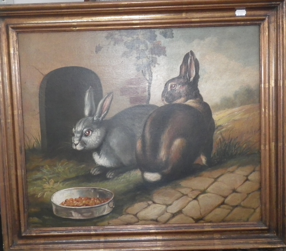 A NAIVE OIL ON CANVAS PAINTING OF TWO RABBITS FEEDING IN A GARDEN in a gilt frame