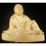 A JAPANESE CARVED IVORY NETSUKE, EDO PERIOD, EARLY 19TH CENTURY, modelled as a seated figure holding