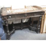 A 19TH CENTURY WALNUT CENTRE TABLE with profuse carving, the top set with a needlework panel,105cm