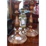 A PAIR OF 19TH CENTURY COPPER CANDLESTICKS with an armorial crest, 26cm high