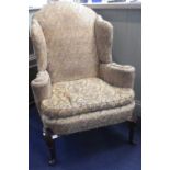 A GEORGE II STYLE UPHOLSTERED WING ARMCHAIR, with scrolling arms and mahogany cabriole legs, 84cm