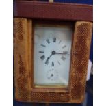 AN EDWARDIAN BRASS CASED CARRIAGE CLOCK with leather outer case