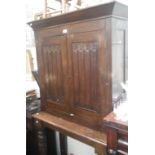 A 19TH CENTURY OAK CABINET ON STAND with (re-used) linen fold panels, 98cm wide