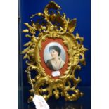 A CONTINENTAL PLAQUE OF A YOUNG WOMAN in a git cast iron rococo frame, 31cm high