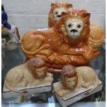 A PAIR OF LARGE STAFFORDSHIRE LIONS, 27cm wide and a similar pair