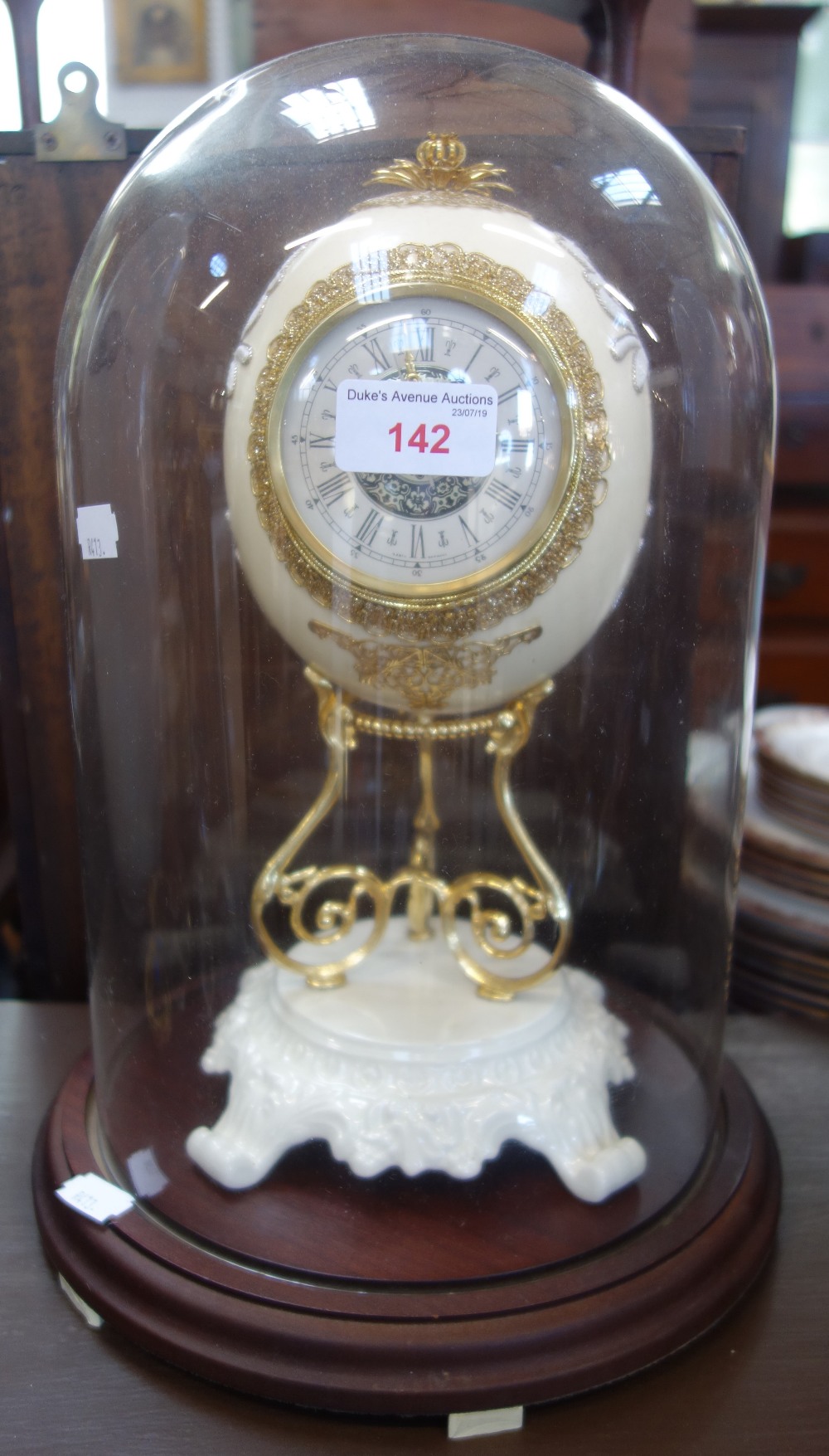 AN OSTRICH EGG MANTEL CLOCK under a glass dome