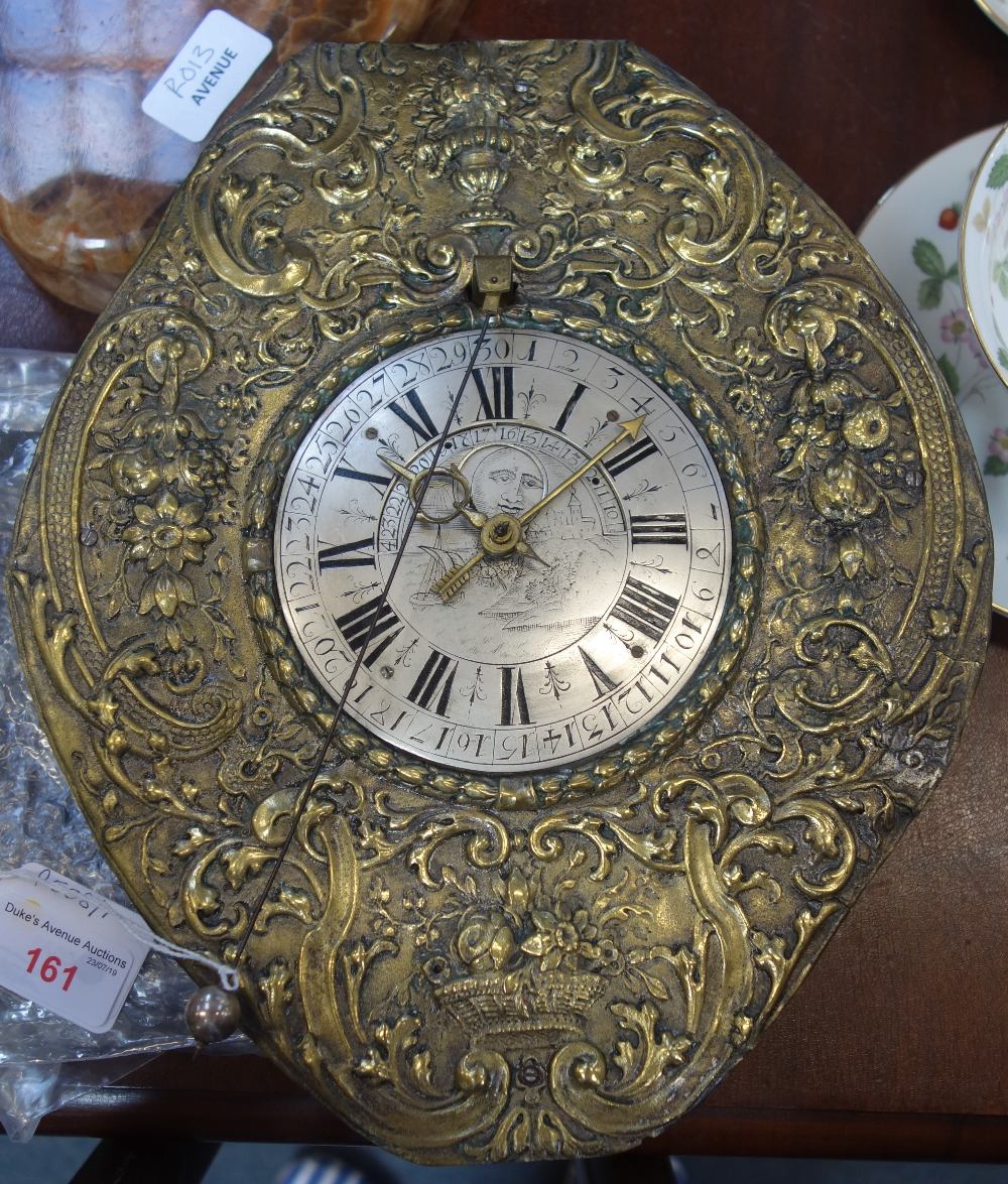 A CONTINENTAL EMBOSSED BRASS "TELLERUHS" WALL CLOCK, the silvered dial with Roman nu-merals, moon