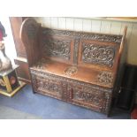 A VICTORIAN CARVED OAK HALL SETTLE with initials N.E. (possibly surname is 'Ester' from Ormskirk),