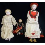 AN 1880'S GERMAN BISQUE DOLL, with traditional German costume, 33cm high and two smaller