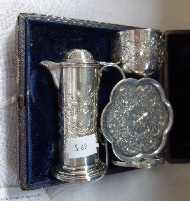 A VICTORIAN SILVER TRAVELLING COMMUNION SET, in a fitted leather box, Chalice, patten and flagon