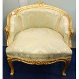 A FRENCH GILT FRAMED TUB CHAIR upholstered in damask