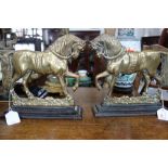 A PAIR OF VICTORIAN BRASS DOOR STOPS in the form of horses on painted iron bases