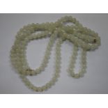 A PALE GREEN JADEITE NECKLACE, with gold clasp, 122cm long