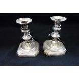 A PAIR OF SILVER CANDLESTICKS (filled)