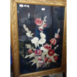 A WOOLWORK PICTURE of Hollyhocks in a gilt frame