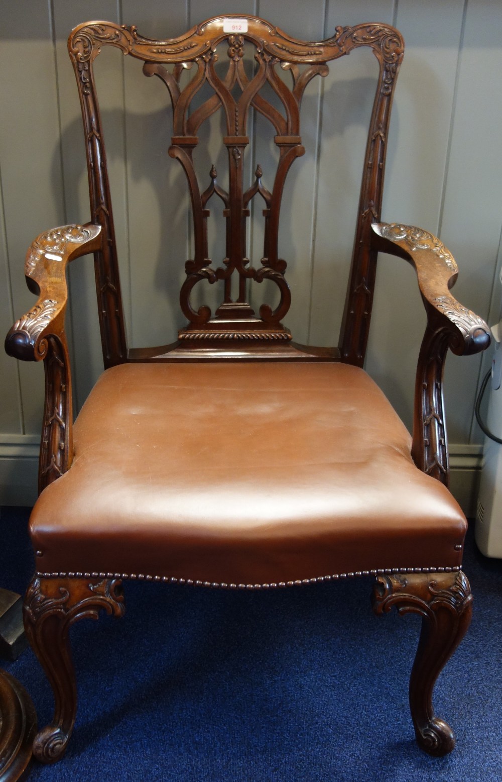 A CHIPPENDALE STYLE MAHOGANY CARVER CHAIR with a brown leather seat