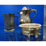 A SILVER PLATED ROCOCO DECORATED LIDDED JUG, a bottle stand and a pewter tankard