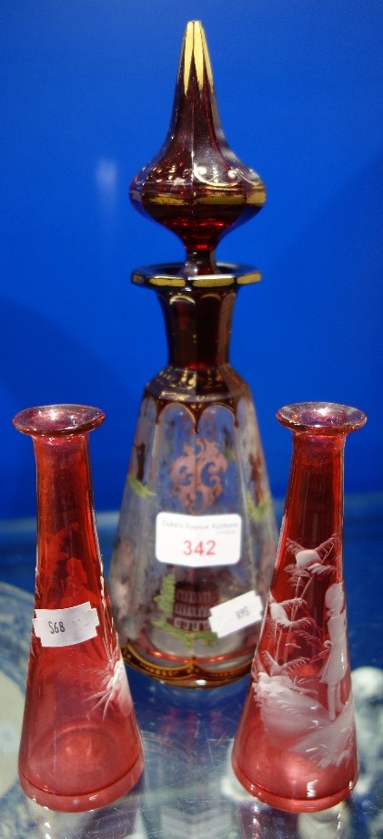 A VICTORIAN BOHEMIAN RUBY OVERLAID CUT GLASS DECANTER, 27.5cm high and a pair of Mary Gregory