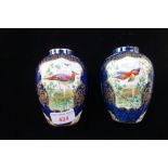 A PAIR OF WORCESTER STYLE VASES, painted in polychrome with gilt highlights, 12cm high (2)