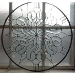 A CIRCULAR LEADED CLEAR GLASS PANEL with radiating scrolling design, 72cm diam