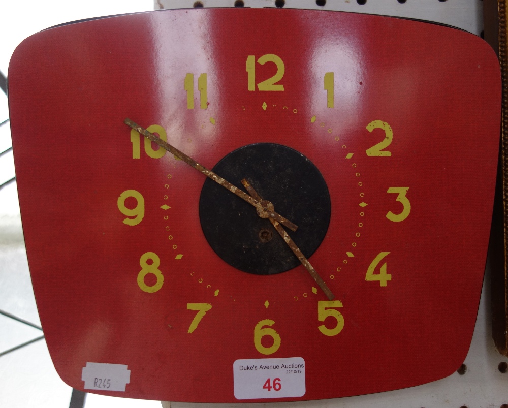 A VINTAGE 1960'S RED FORMICA WALL CLOCK with yellow numerals