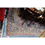 A RED GROUND PERSIAN RUG with floral border on a blue ground. 230cm x 380cm