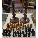 A PAIR OF OAK SPIRAL CANDLESTICKS and a collection of wooden chess pieces from differing sets